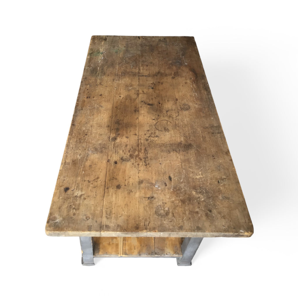 tabletop view of a french farmhouse style work table with a drawer, lower shelf and distressed gray paint