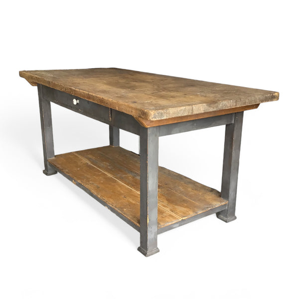 side view of a french farmhouse style work table with a drawer, lower shelf and distressed gray paint