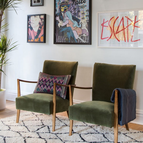 art deco velvet chairs in front of framed art 