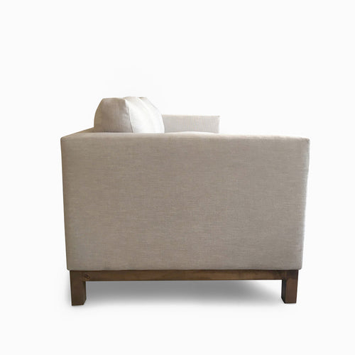 Side view of light beige midcentury sofa made to order with sustainable alder wood.
